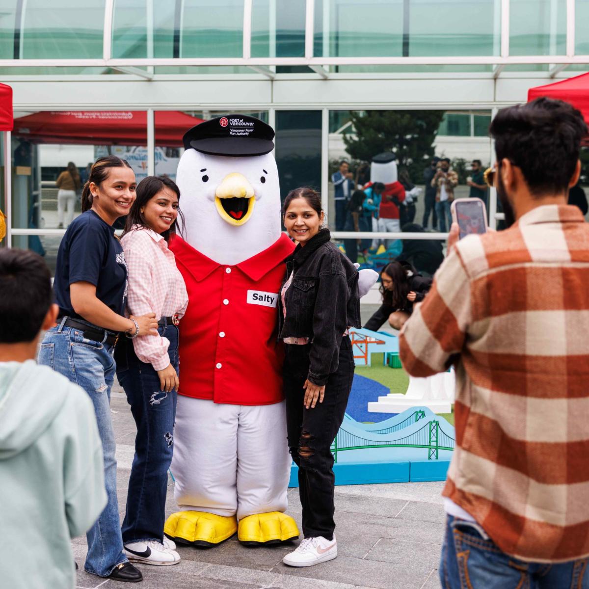 People taking photos with a seagull mascot